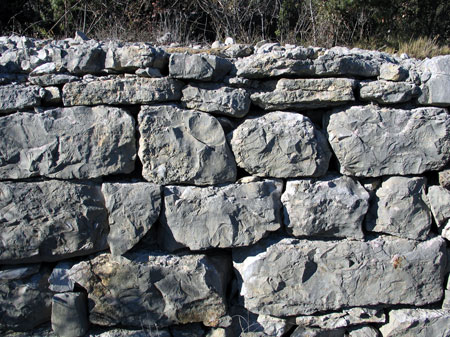 Parement d'un mur de terrasse : les blocs de calcaire dur ont leur face vue soigneusement ragréée (traces d'enlèvement d'éclats conchoïdaux). © Michel Rouvière